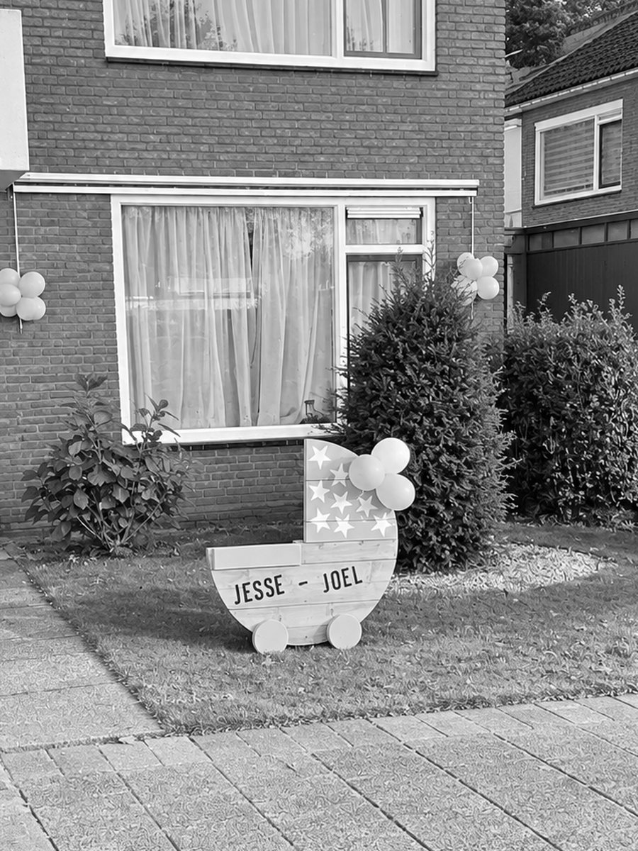 The front of the house with balloons and a wooden pram sign reading Jesse and Joel